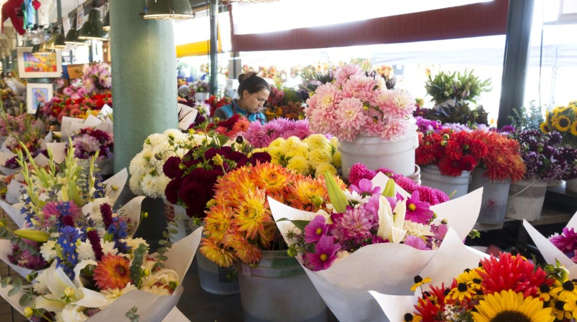 A Pike Place Market flower vendor stands behind her gorgeous colorful bouquets during the Pike Place Market Flower Festival held Mother's Day weekend in Seattle