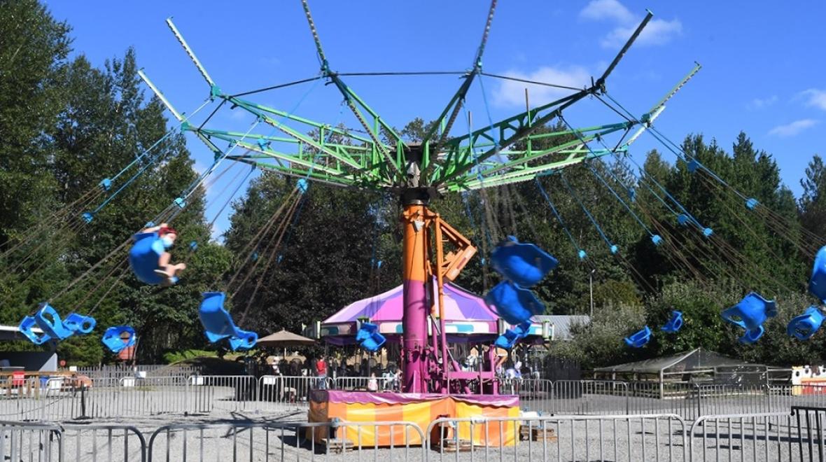 Kids and families enjoy a carnival ride, the spinning swing, at Remlinger Farms a mini theme park near Seattle opening Mother's Day weekend 