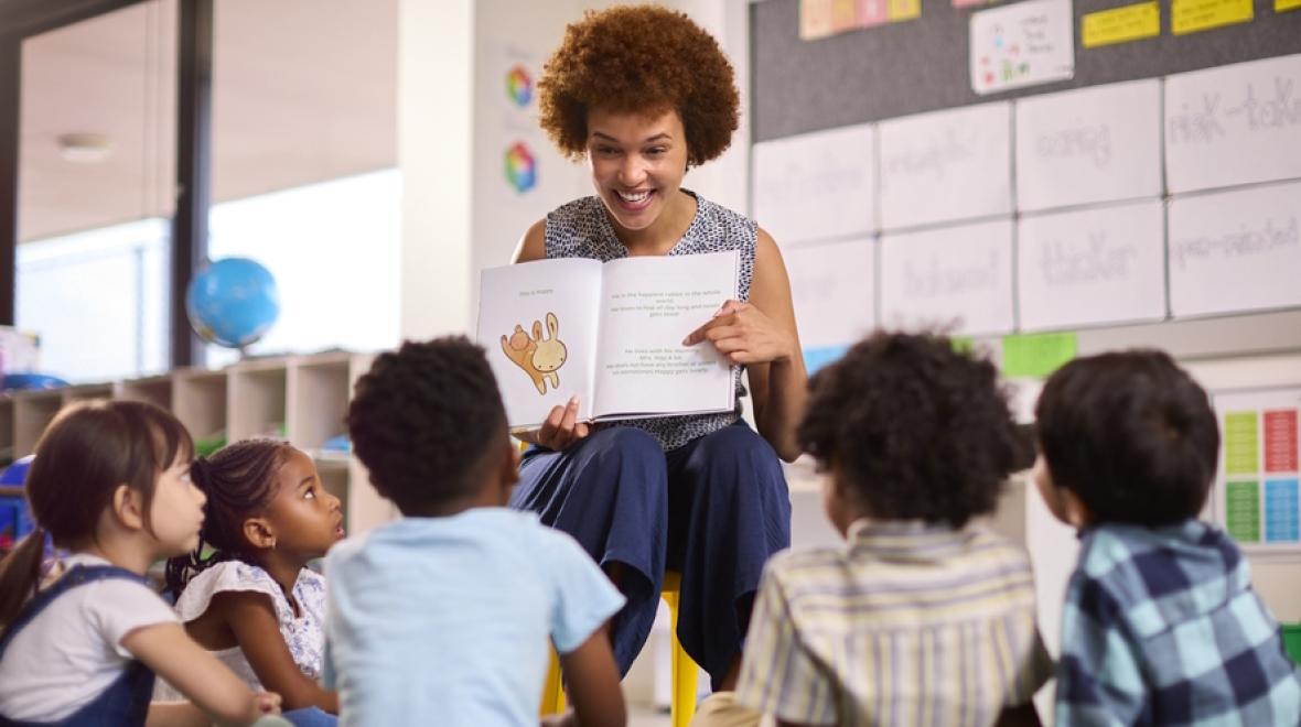 Teacher reading a book to a classroom of children