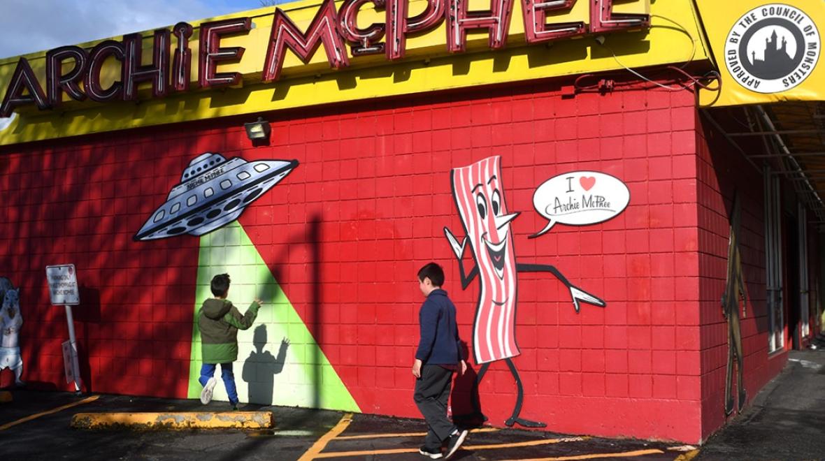 Two elementary age boys stand next to Seattle's Archie McPhee store which celebrates its 40th anniversary in 2023