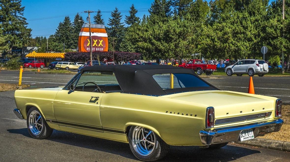 A pale yellow Ford Fairlane GT is parked for a car show at Triple XXX Rootbeer Drive-in Issaquah among family activities in Seattle for car-loving kids and families