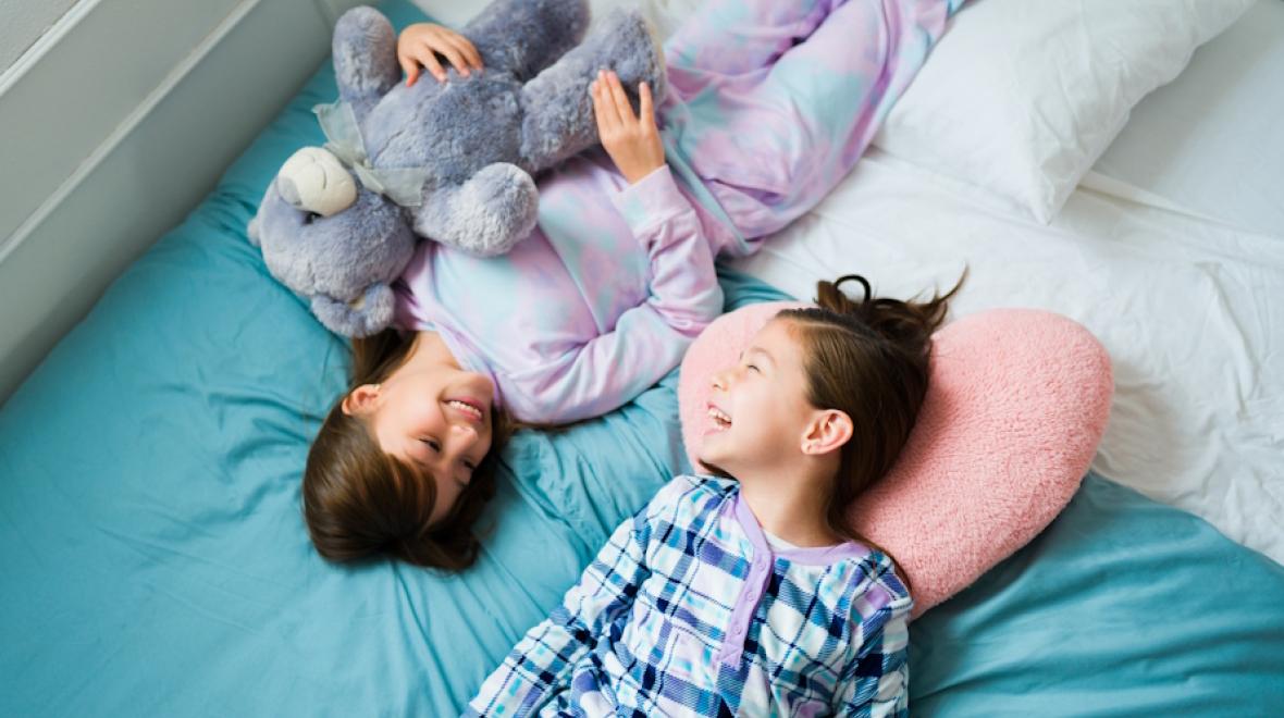 Two girls smiling and laughing at a sleepover