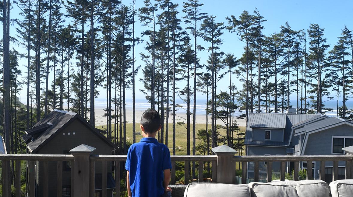 A boy looks out at the view of the Pacific Ocean and the beach from a rental home at Seabrook, Washington, a popular vacation destination for Seattle families