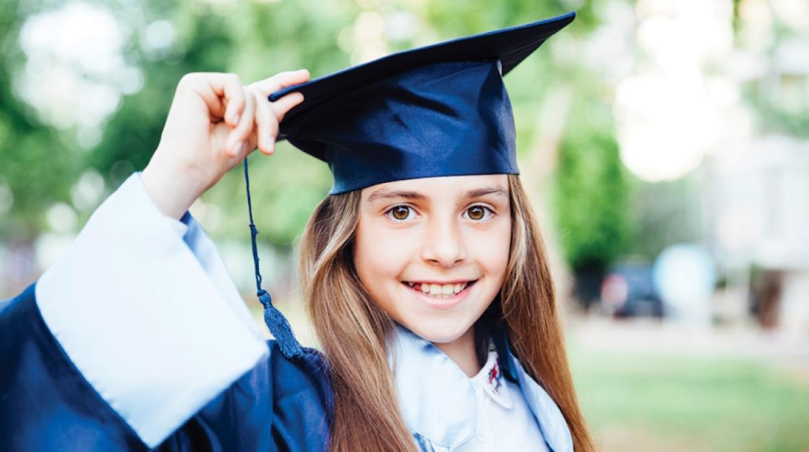 Young girl wearing a college graduation cap and gown
