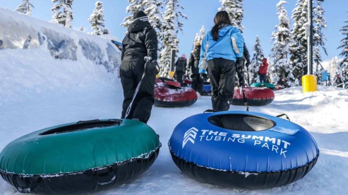 kids haul their tubes up the slopes at Snoqualmie tubing hill a best place to tube near Seattle