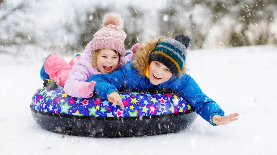 Kids on a sled with the best snow gear and toys