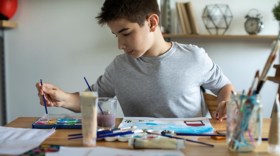 Teen boy painting at home  is a volunteer opportunity for Seattle kids who love crafting