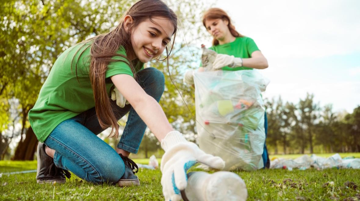 teen girl volunteering at a park clean-up 