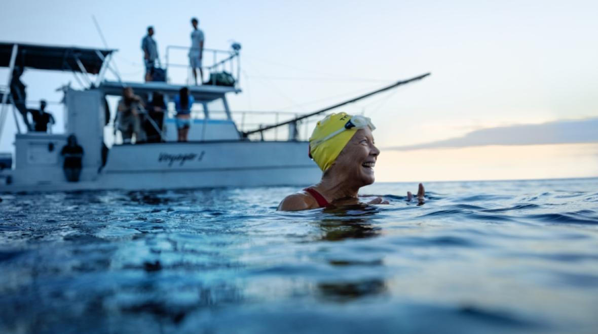 Diana Nyad swimming in the ocean with a boat behind her