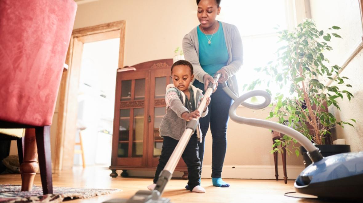 Little boy helping his mom vacuum