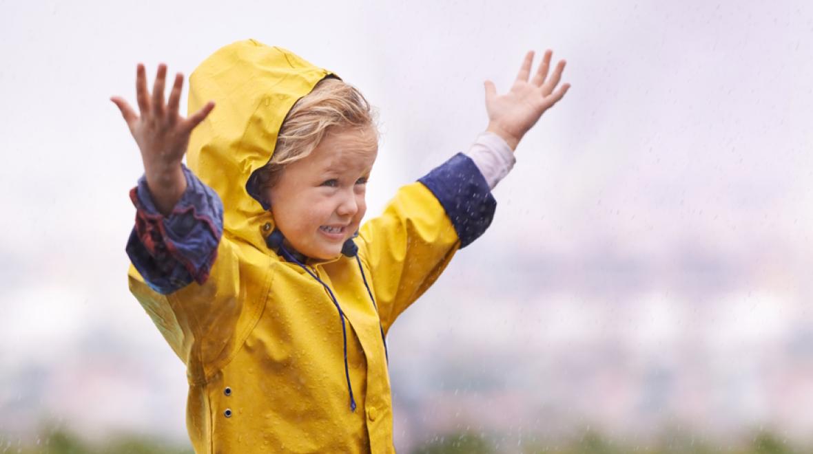 little girl in the rain embracing the bad weather