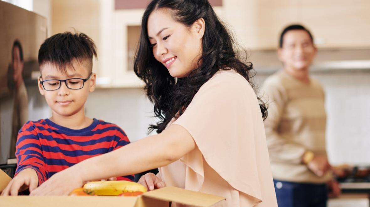 Mom and son opening up a meal prep box part of a Seattle meal kit service