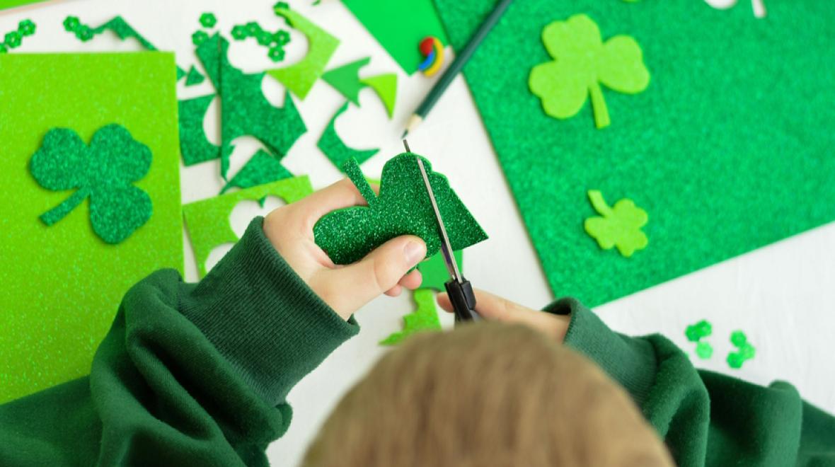 Child cutting out St. Patrick's day crafts for kids