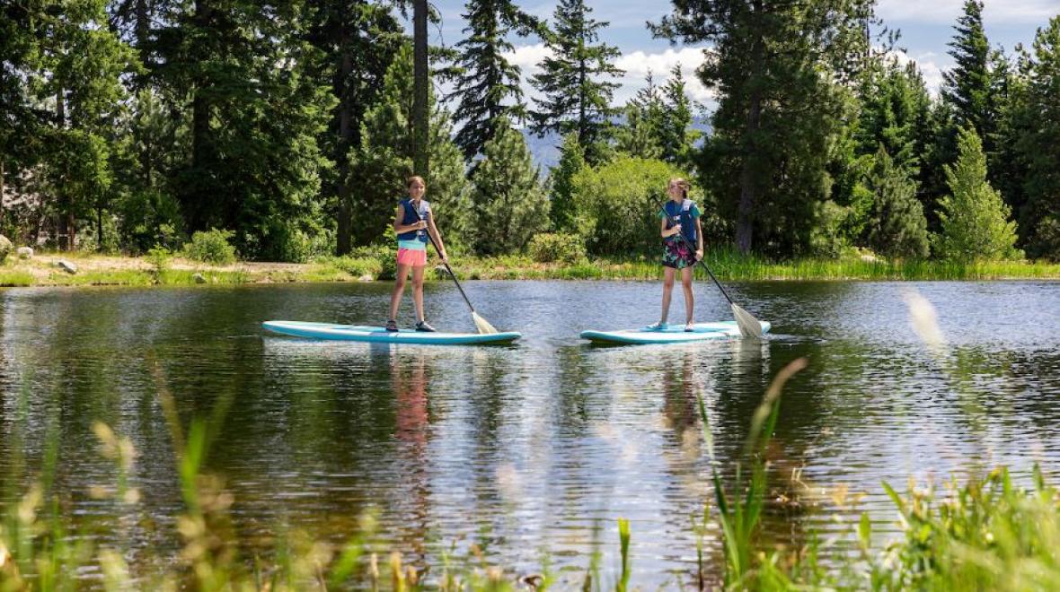 boy and girl paddle boarding at Suncadia Resort