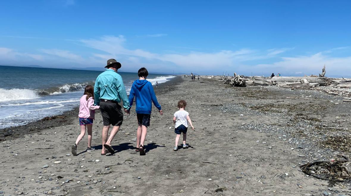 family walking hand in hand along the beach at Dungeness Spit