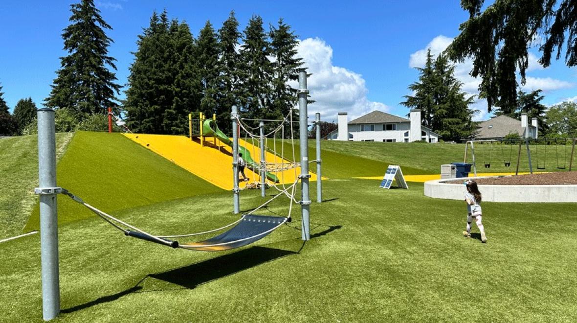 A young child heads toward the fun playground structure at 132nd Square Park on the Eastside