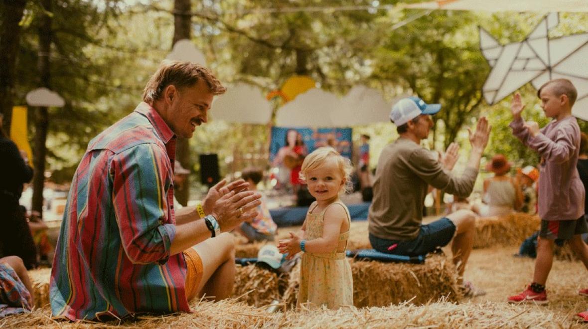 young girl plays at an outdoor Seattle music festival with her dad