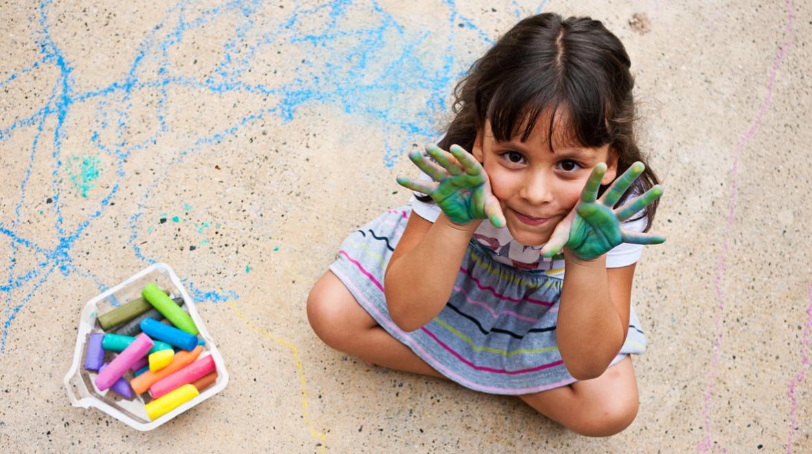 a child plays with sidewalk chalk which makes a great birthday party favor