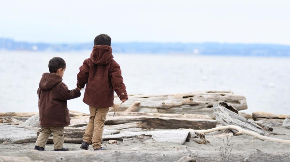 two young boys holding hands on a beach near Seattle, a fun fall activity for families