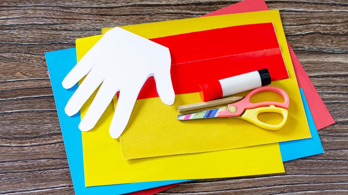 cut out hand print and pile of craft supplies