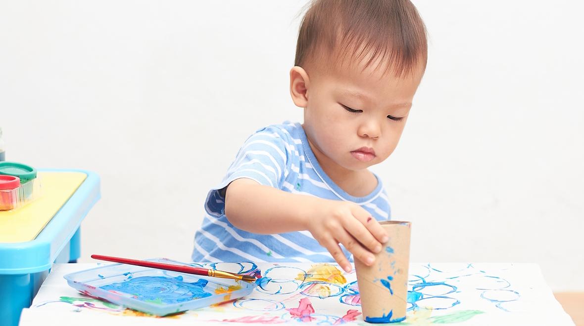 little boy stamping with a toilet paper roll