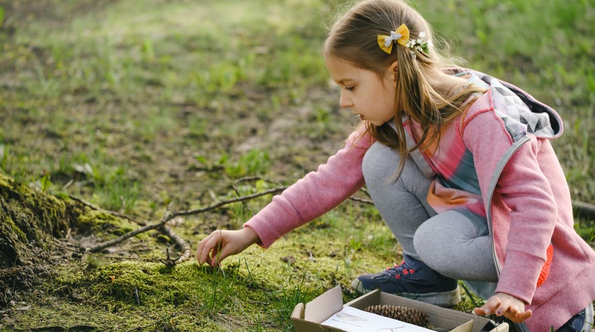 girl finding objects for an outdoor nature hunt
