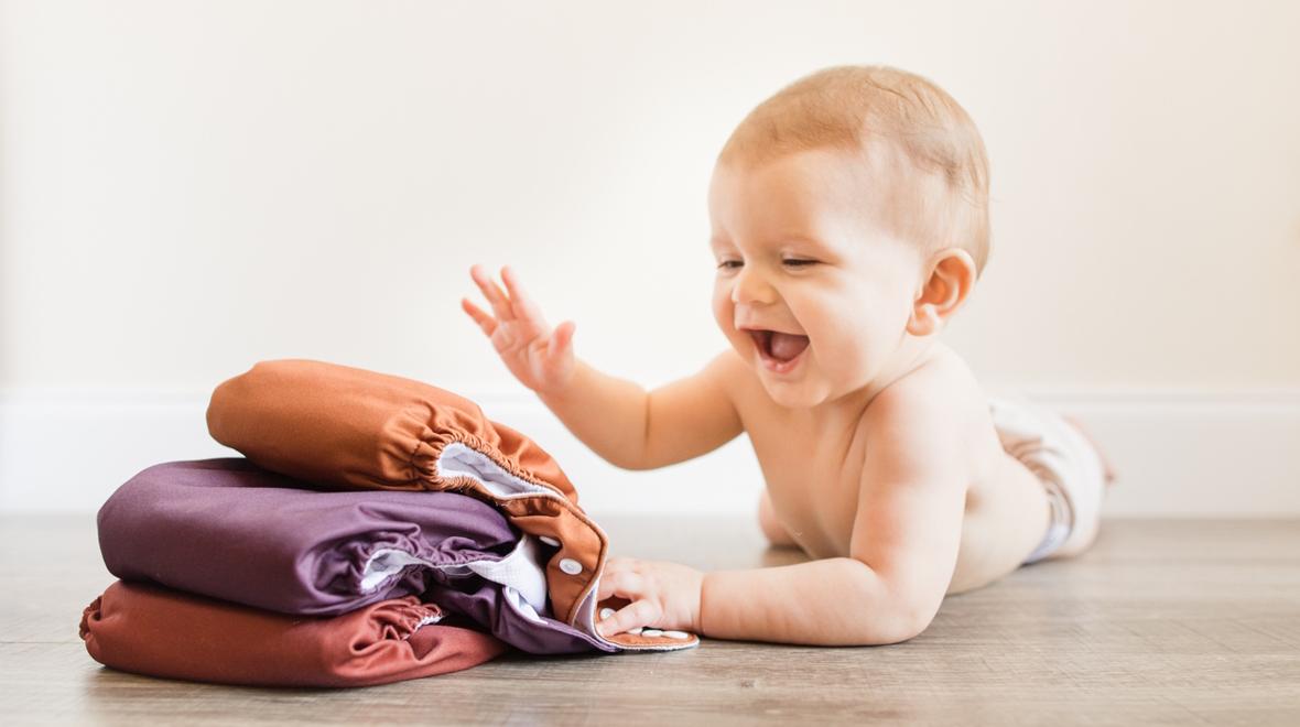 Baby with a stack of cloth diapers