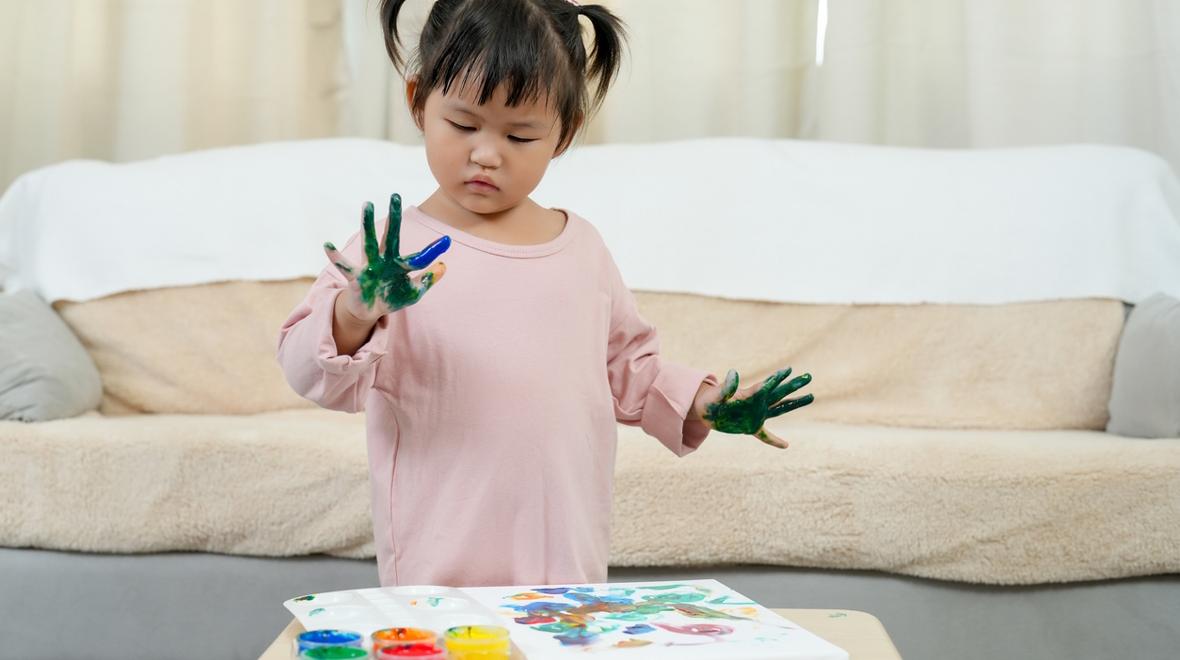 child playing with fingerpaint