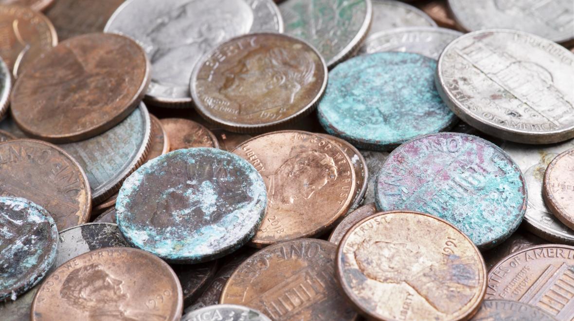 a pile of change with a few pennies that have turned green