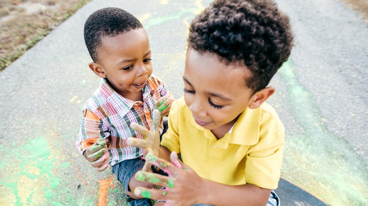 young boys painting on the sidewalk with liquid chalk paint