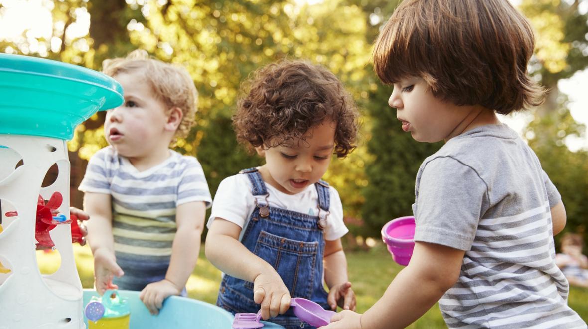 three kids playing in the water outside during the summer 