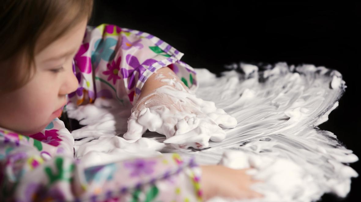 Little girl playing with shaving cream