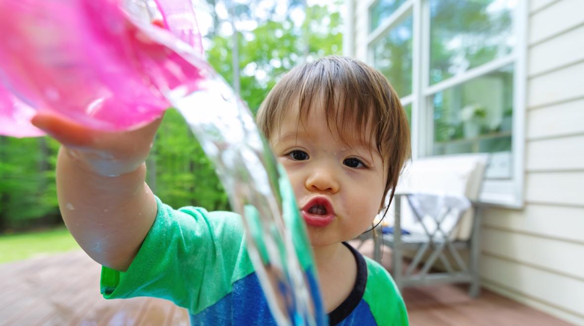child playing with water outside