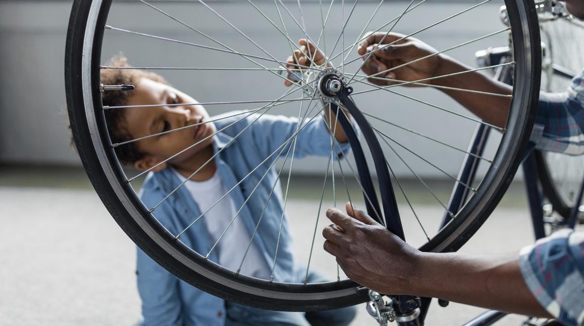 kid looking at his bike tire getting ready for a spin art project