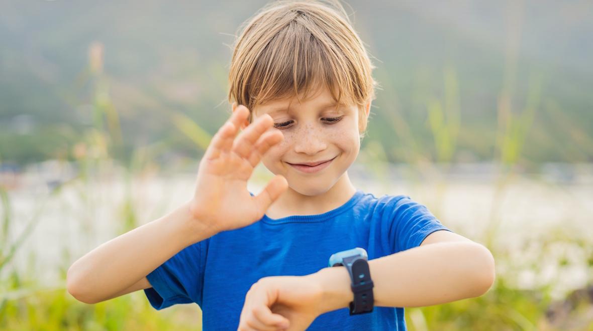 child talking on a smart watch out in nature