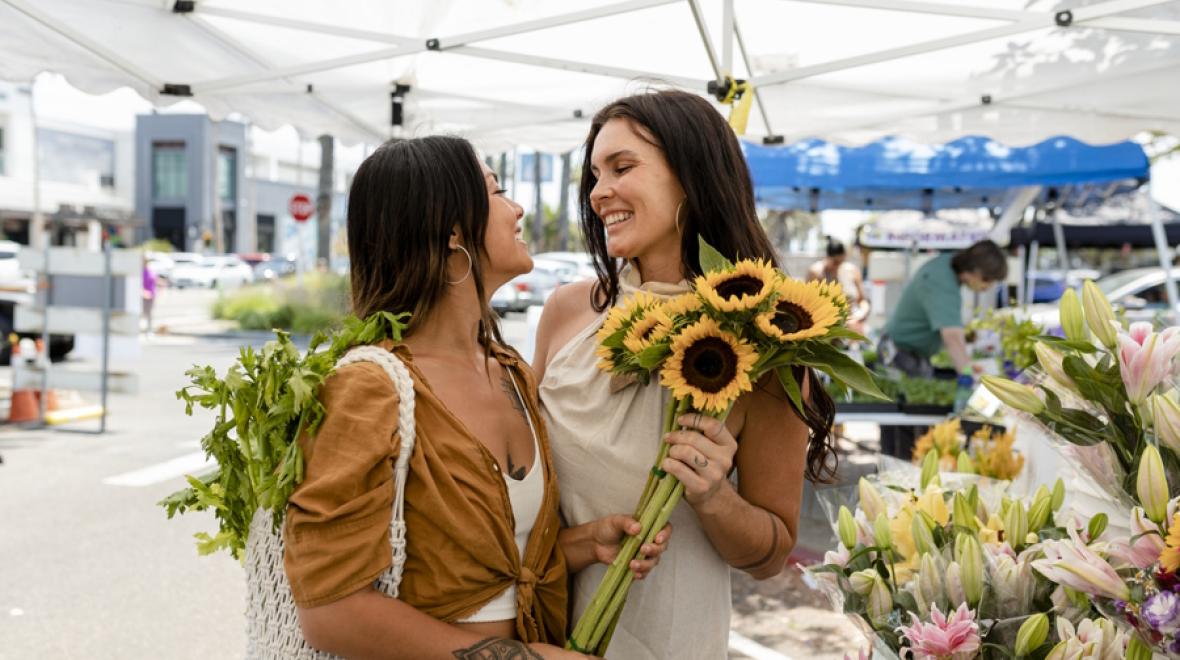 couple at a local farmers market buying flowers having a summer date night