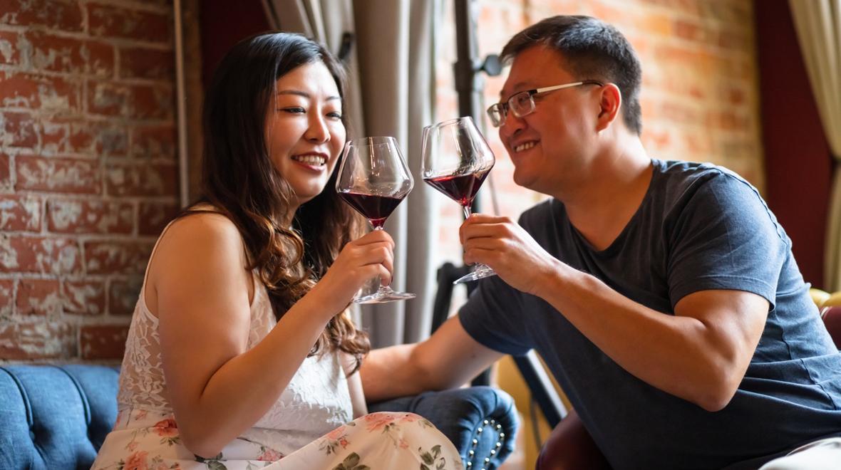 couple enjoying a glass of red wine at their favorite bar as a summer date night