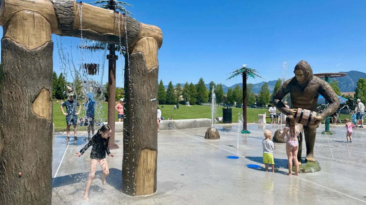 kids playing at the new splash pad in snoqualmie with a Sasquatch and waterfall