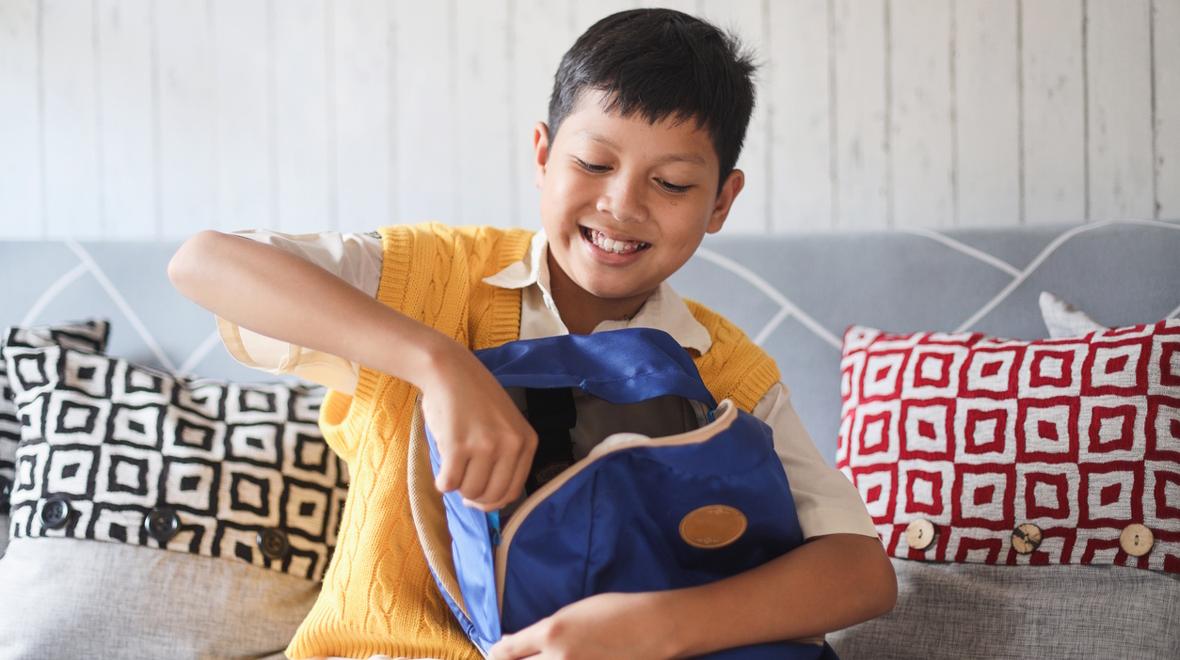 boy packing his backpack before school 