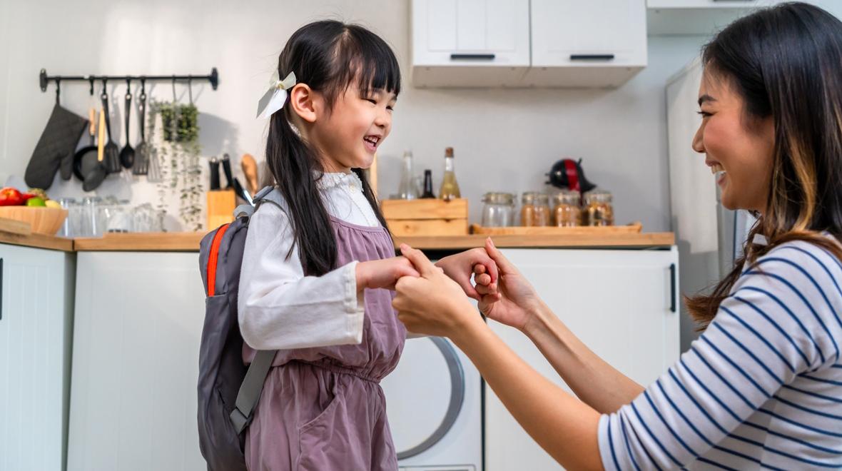 Happy girl and her mom on her way to school