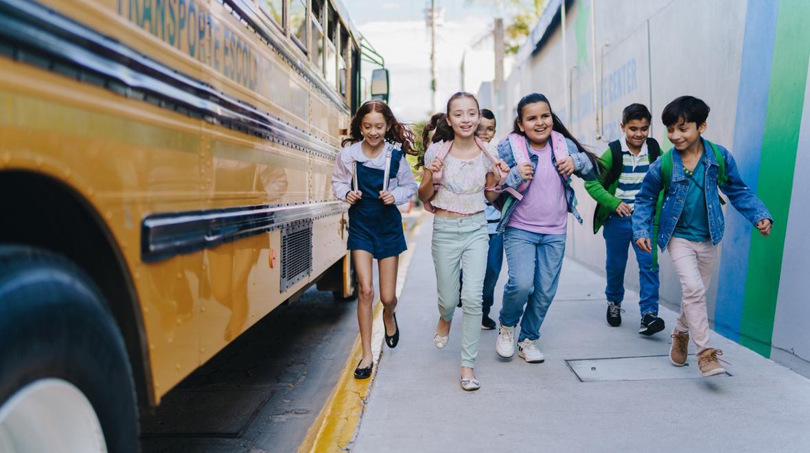 kids walking next to a school bus back to school
