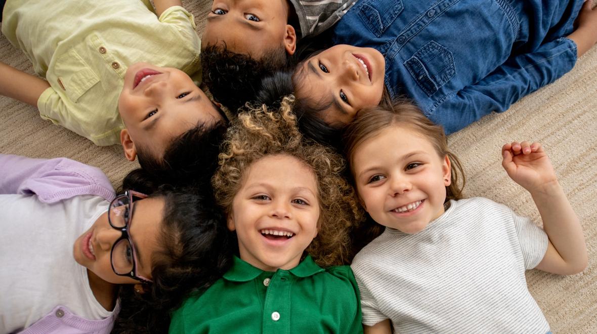 kids lying down with their heads together