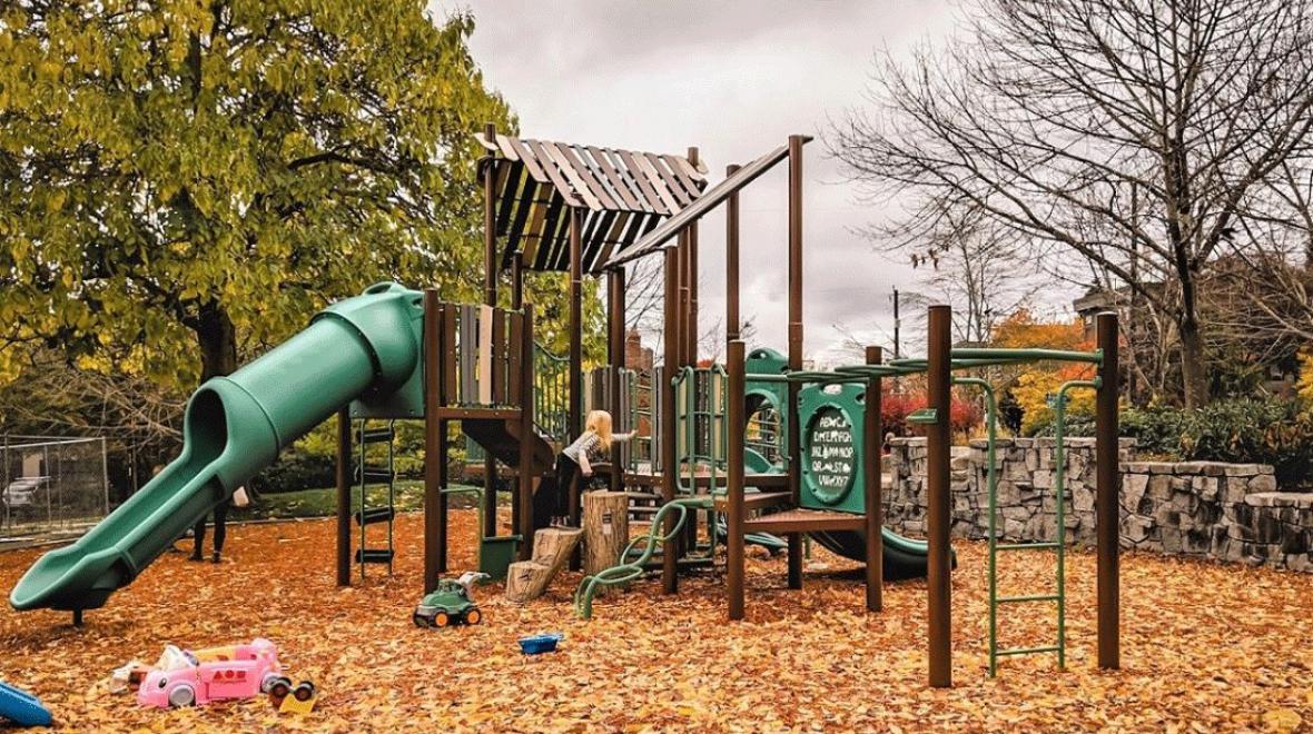 a young girl playing on a playground on an overcast rainy day in Seattle