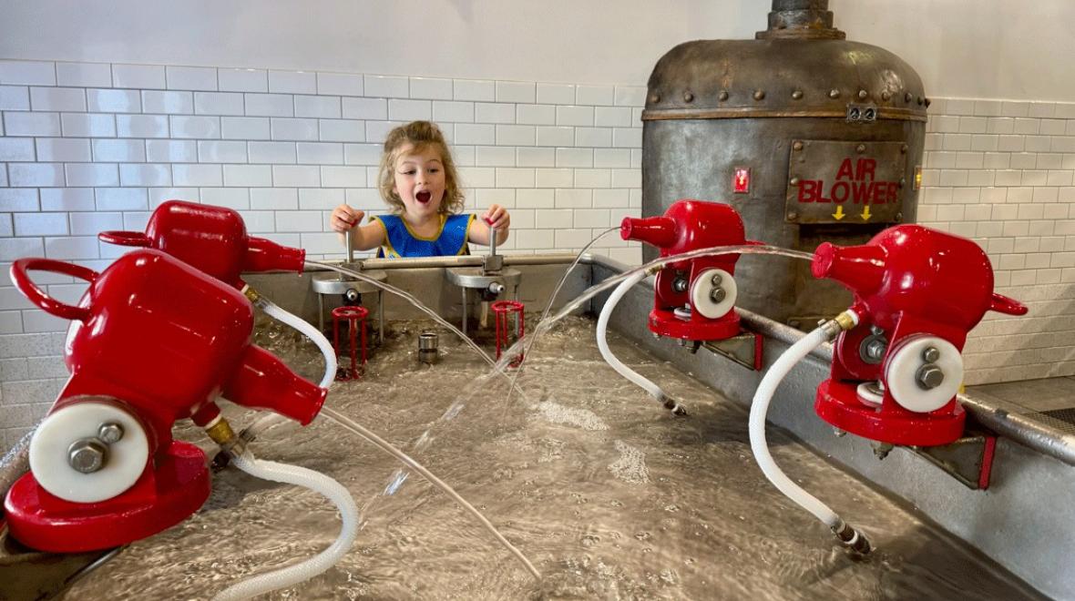 young child playing with the water features at Imagine Children's Museum on a toddler-friendly outing