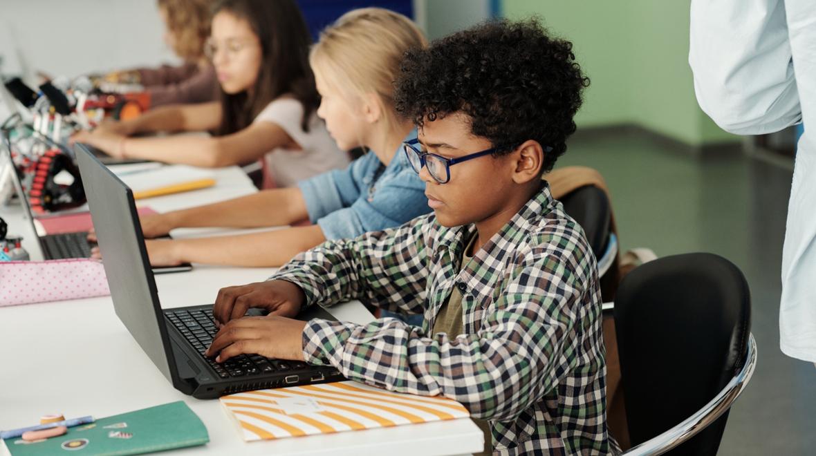 boy using a laptop in a classroom