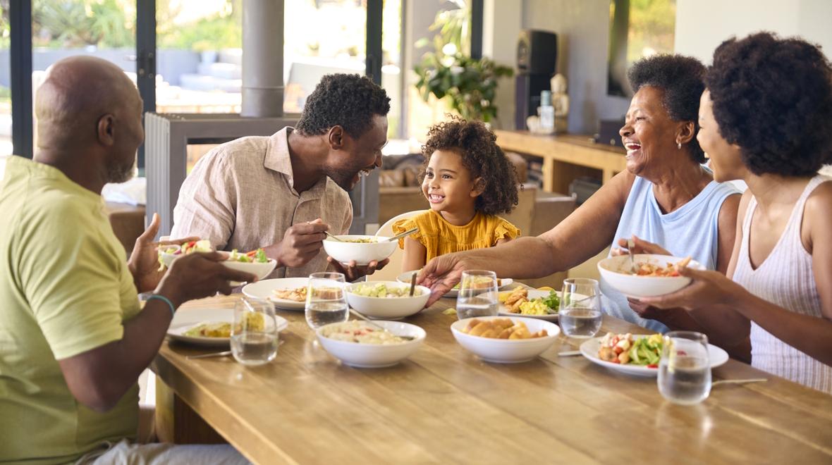 family sitting around dinner table eating together