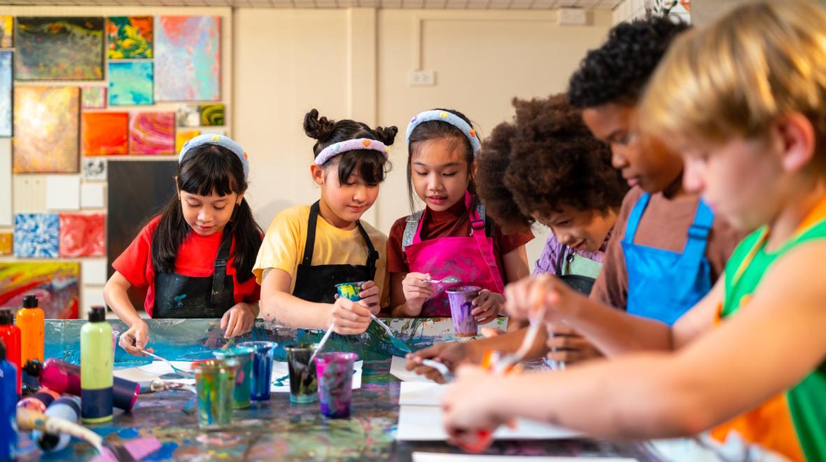 kids sitting around a table engaged in an art project