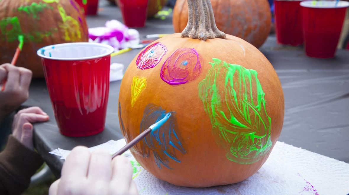 pumpkin being painted with bright colors