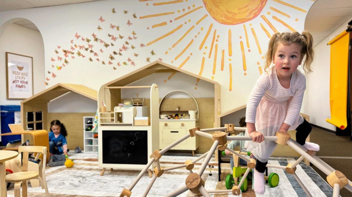 young child on wooden climbing gym at Laro Tayo, an indoor play space for families in Kent