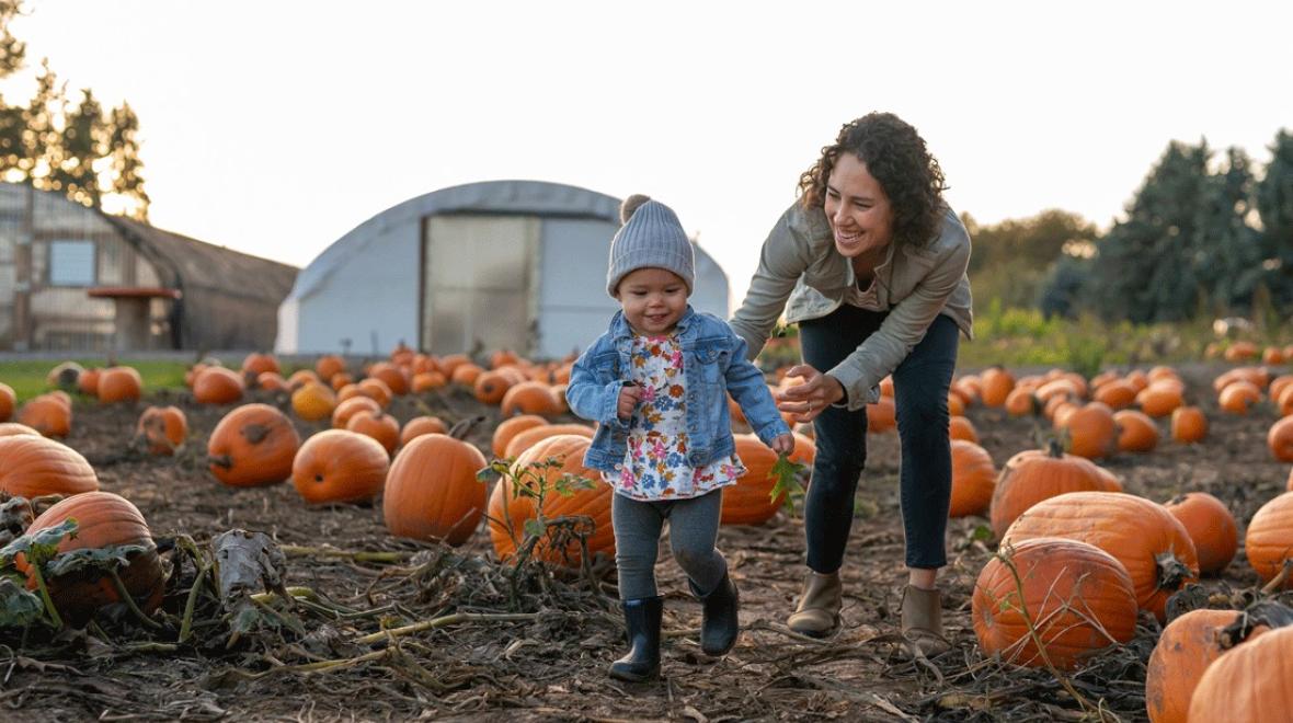 mom and young child exploring a pumpkin patch during a fall outing near Seattle